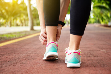 Wall Mural - runner woman tying up laces of shoes, getting ready to run for cardio and weight loss