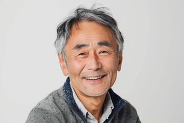 Poster - Portrait of a tender asian man in his 70s smiling at the camera while standing against white background