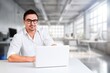 © BillionPhotos.com - Portrait of smiling businessman using computer in modern office.