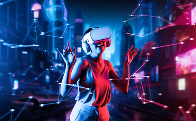 Wall Mural - Female standing in virtual reality cyberpunk style building in meta wearing VR headset connecting metaverse, future cyberspace community technology, She enjoy dancing raising two arms. Hallucination.