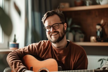 Wall Mural - Portrait of a grinning man in his 30s playing the guitar over modern minimalist interior