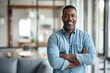 © CogniLens - Portrait of a satisfied afro-american man in his 40s with arms crossed while standing against modern minimalist interior