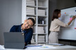 © Wasana - A man is laughing on the phone while sitting at a desk with a laptop