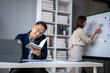 © Wasana - A man is sitting at a desk with a book in front of him