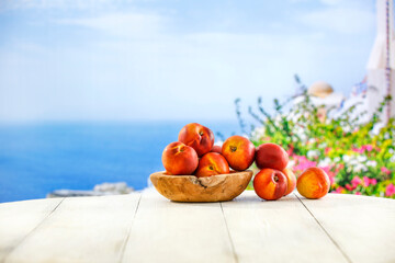 Sticker - Fresh tasty fruits of peaches and white wooden table of empty space for your decoration. Summer landscape and natural sun light. 