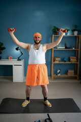 Wall Mural - Man lifting dumbbells during home workout, focusing on upper body strength.