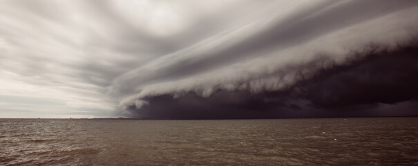 Wall Mural - Cloudy storm in the sea before rainy.tornado storms cloud above the sea. Monsoon season. Storm in the sea.Wonder of natural disaster.Cloud before rain,Sky before the storm.use for background wallpaper