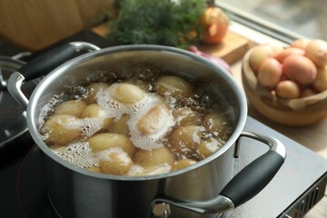 Wall Mural - Boiling potatoes in pot on stove in kitchen