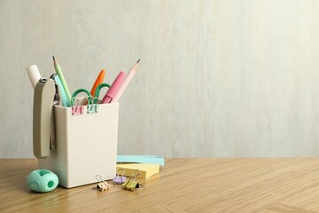 Wall Mural - Stapler, holder and other different stationery on wooden table, space for text