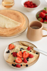 Wall Mural - French homemade pancake crepes with strawberries. Summer breakfast. Front view