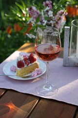 Canvas Print - Vase with spring flowers, wine and cake on table served for romantic date in garden