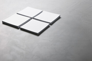 Sticker - Blank paper sheets on grey textured table, closeup. Mockup for design