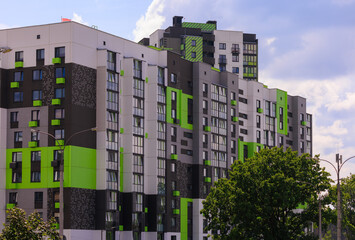 Cityscape on a summer day, modern buildings and houses against the blue sky 