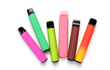 A set of colorful disposable electronic cigarettes of different shapes on a white background. modern smoking. top view 
