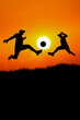 © STOCK PHOTO 4 U - Silhouetted Soccer Players Kicking Ball at Sunset with Bright Sun in Background