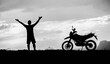 © STOCK PHOTO 4 U - Silhouette of a Man with Raised Arms Standing Beside a Motorcycle Against a Dramatic Sky