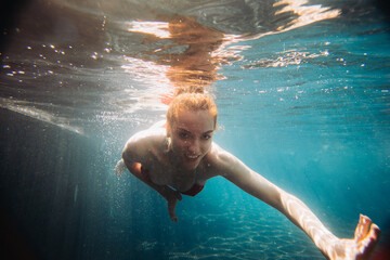 Underwater woman portrait in swimming pool..