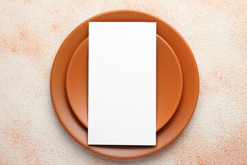 Wall Mural - Empty menu and plates on color textured table, top view. Mockup for design