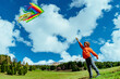 © chaossart - Happy boy with kite on green field on mountains background
