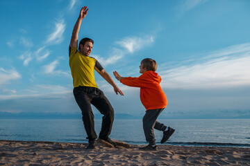 Sticker - Father and son playing tag on lake shore on summer day at sunset