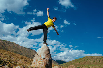 Poster - Man balance on huge boulder in mountains on summer day