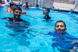 © Viga - Portrait for young males in the swimming pool enjoy there time during summer time under the sun shines cooling themselves and looking at the camera