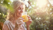 © Pro Hi-Res - Happy woman enjoying a glass of orange juice on a sunny day.