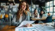 © Lens Legacy - An attractive woman in professional attire reviews financial reports at her desk inside an office setting