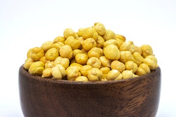 Wall Mural - Closeup of Roasted Garbanzo Bean or Chickpea in a Wooden Bowl Isolated on White Background with Copy Space, Also Known as Bengal Gram or Egyptian Pea