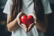 © MadMouse - Young woman holding a red heart in her hands