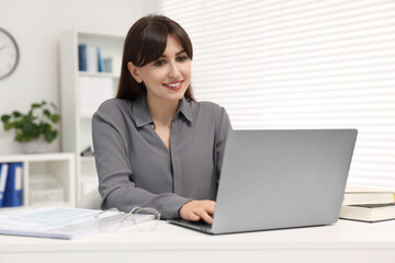 Poster - Smiling secretary working with laptop at table in office