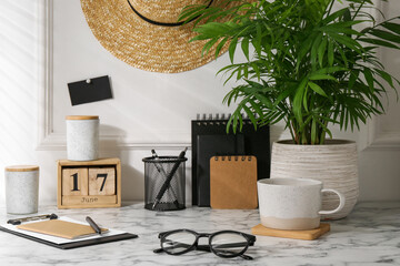 Wall Mural - Stylish office workplace. Decor elements, glasses, cup and stationery on marble table near white wall