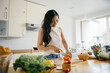 © Parichat - Young Woman Preparing Fresh Vegetables in a Bright Modern Kitchen with Natural Light