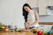 © Parichat - Young Woman Preparing Fresh Vegetables in a Modern Kitchen for a Healthy Meal