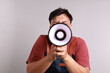 © ArvStd - Young asian man barista barman employee wear blue apron work in coffee shop standing while holding a megaphone