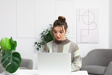 Wall Mural - Female freelancer working with laptop at table in office