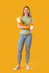 Poster - Young woman with air freshener and cleaning sponge on orange background