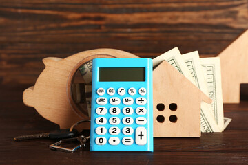 Sticker - Calculator with house model, piggy bank and money on wooden table