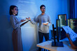 © weedezign - asian developer leads present code review session, pointing at code projected on the wall with colleagues  teamwork and knowledge sharing in software development.