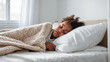 © Syrtseva Tatiana - Portrait of a sick or tired African American child lying in a white bed at home. Sleeping kid