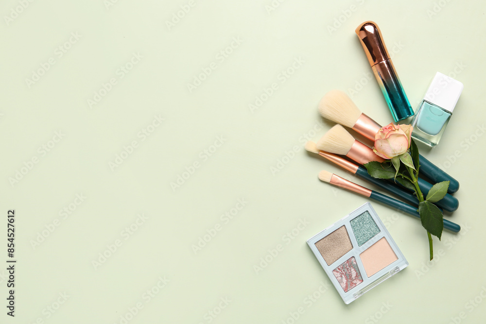 Composition with makeup products and beautiful rose flower on green background