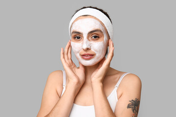 Wall Mural - Young woman with applied mask on light background