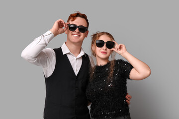 Canvas Print - Young couple in sunglasses on grey background. Black Friday sale