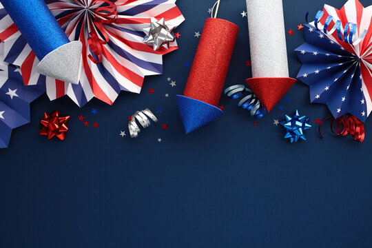 Top view of Independence Day background with firework rockets, paper fans, party streamers.