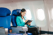 © Phushutter - A reliable Asian businesswoman wearing a formal suit airplane passenger, traveling for business or study abroad. She embodies professionalism and determination in an international setting.