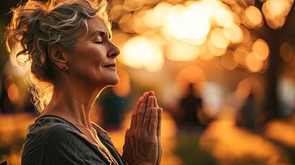 Canvas Print - Mature woman practicing yoga in group outdoors, defocused people on background.