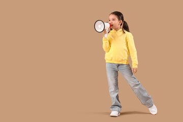 Wall Mural - Portrait of fashionable little girl with megaphone on beige background