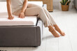 © Pixel-Shot - Young woman sitting on soft mattress in bedroom