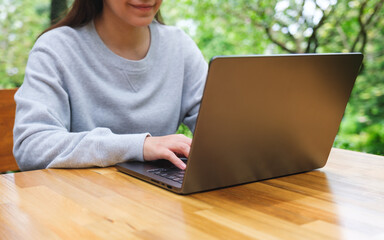 Canvas Print - Closeup image of a woman working and typing on laptop computer keyboard in the outdoors