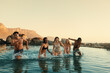 © Jacob Lund - Friends swimming in pool at sunset during summer vacation, enjoying fun and laughter